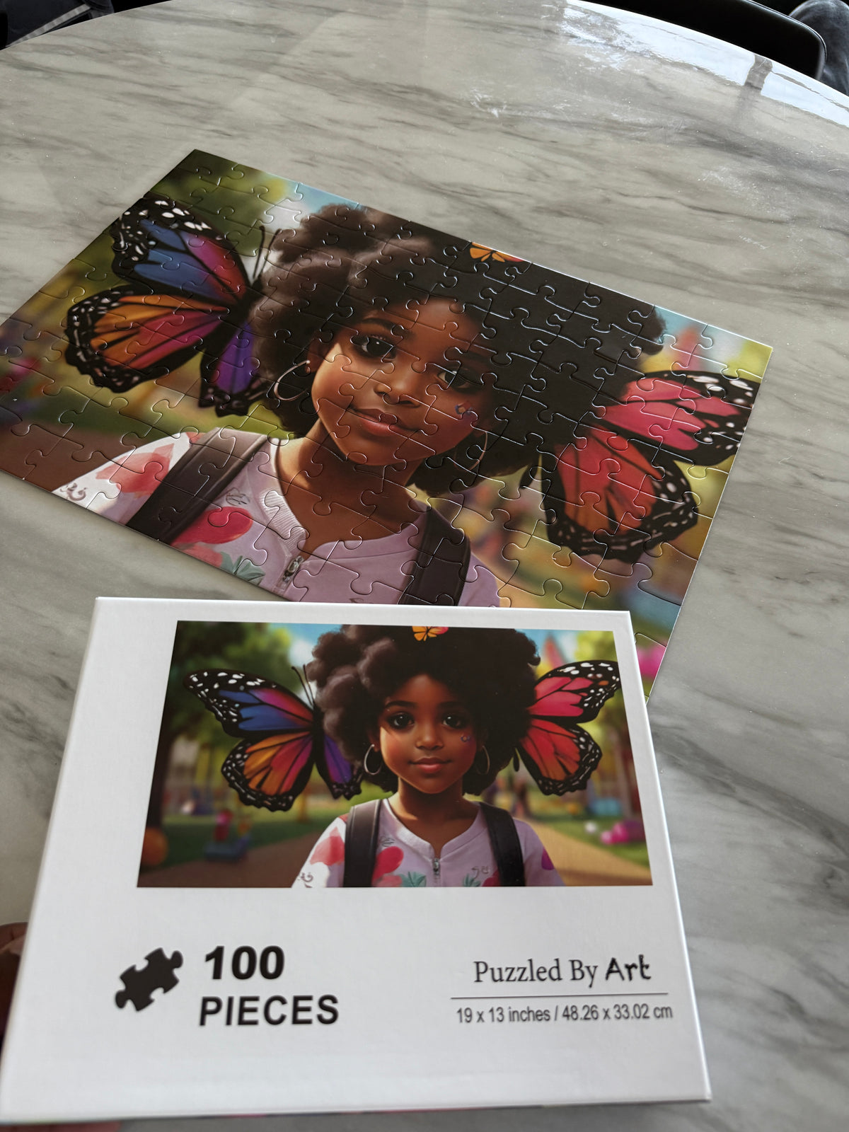 Completed B.G.M kids puzzle next to its 100 piece box